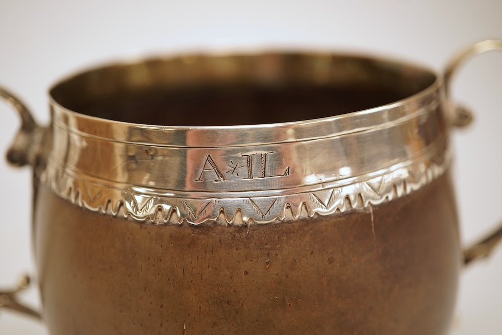 A late 19th/early 20th century white metal mounted two handled coconut cup, with engraved mounts and initials 'A IL', height 10cm (unmarked).